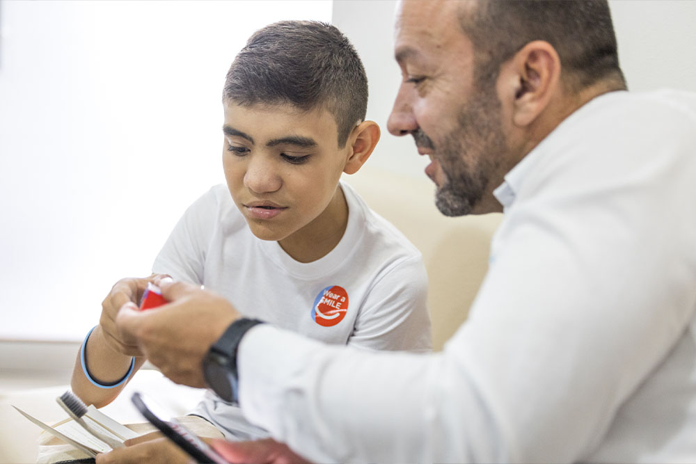 Iván and a young patient are fascinated by a toy