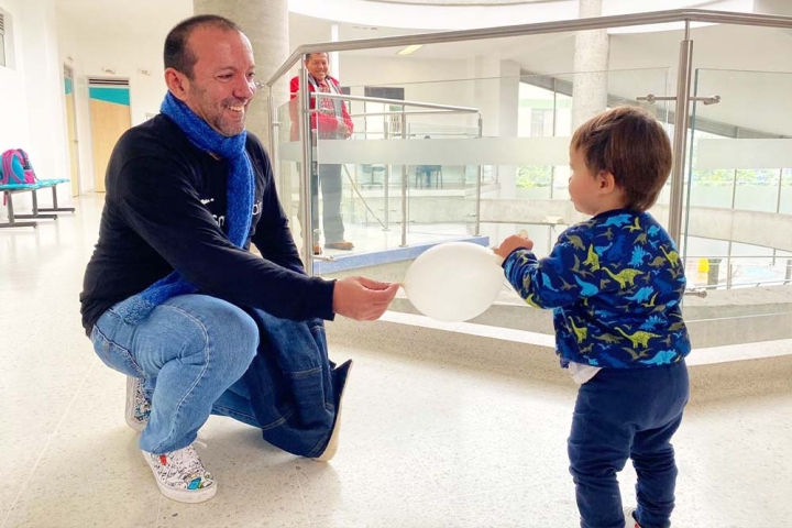 Iván and a young patient play with a balloon