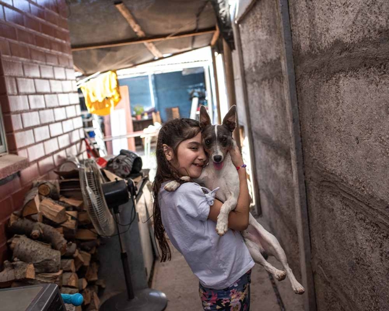 Aylen smiling and hugging her dog after cleft surgery