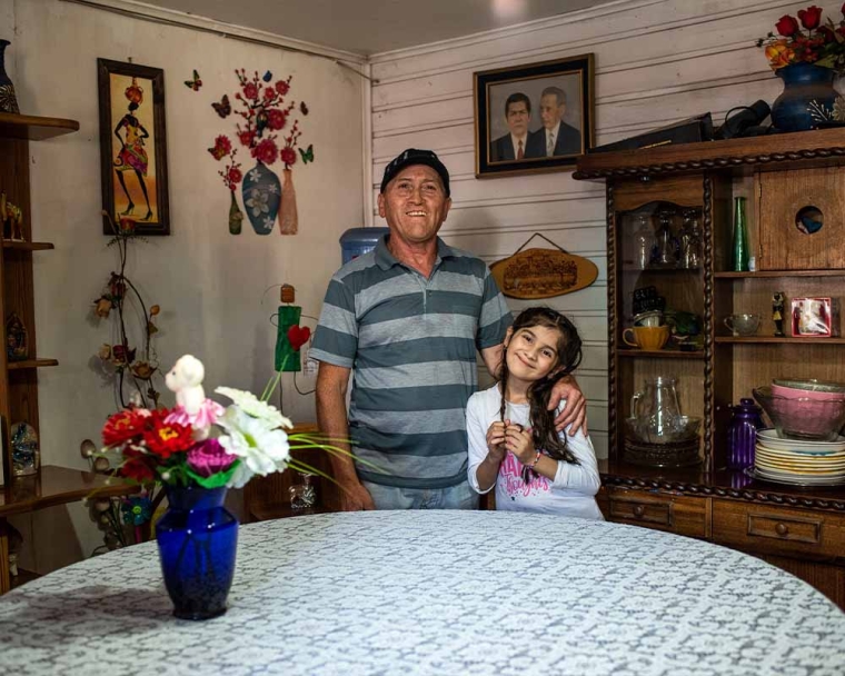 Aylen smiling with her father and some flowers after cleft surgery